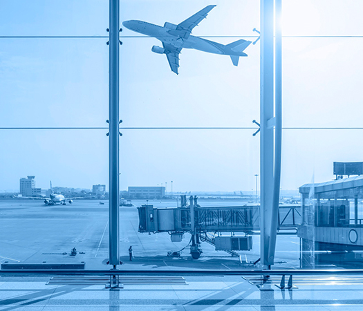 A view of an airplane taking off from an airport terminal, symbolizing the departure of a patient traveling to Natural Clinic for a female hair transplant journey