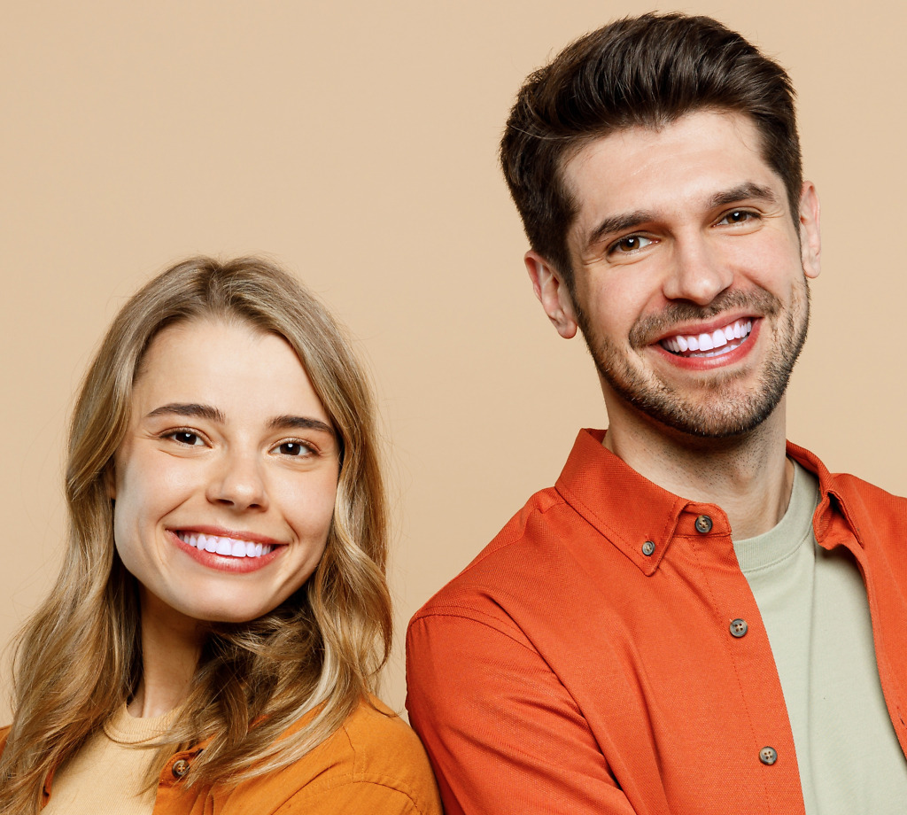 Two smiling individuals showcasing composite veneers treatment at Natural Clinic