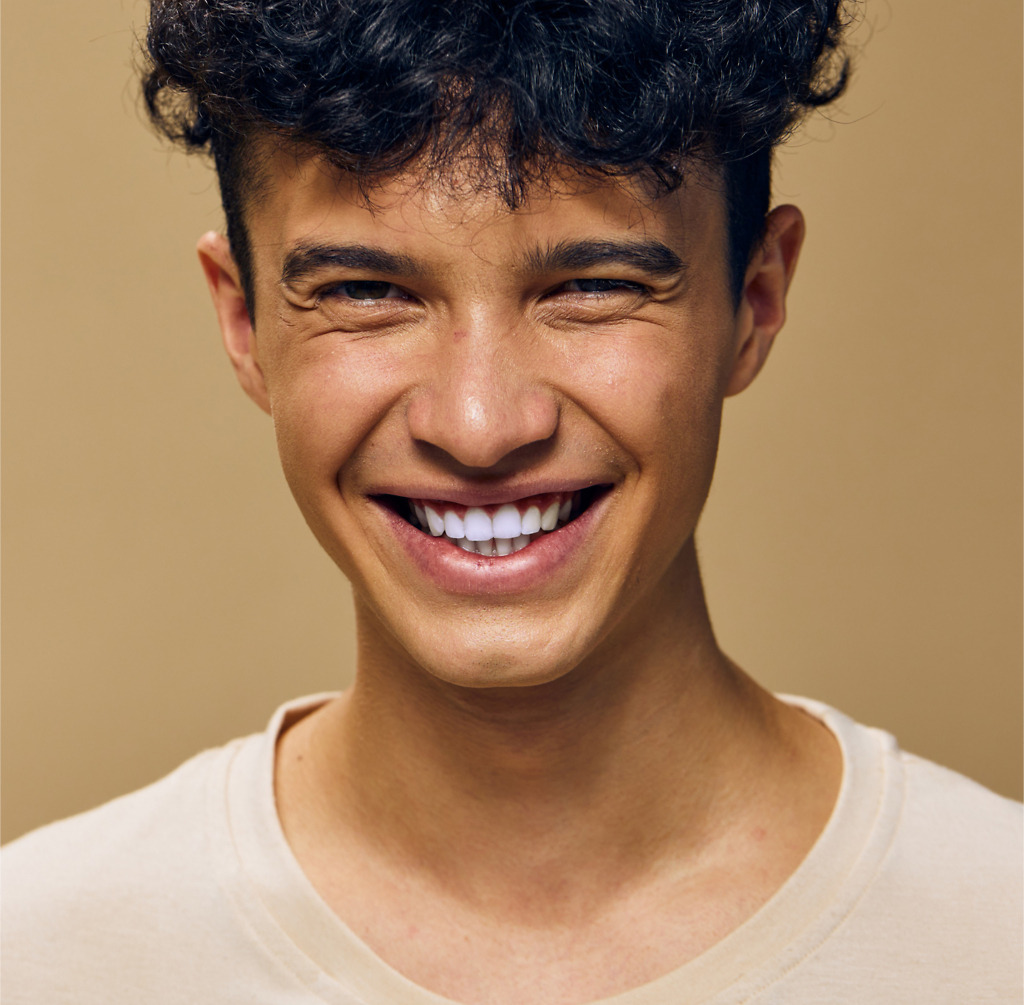 Young male smiling with Emax porcelain veneers at Natural Clinic in Turkey