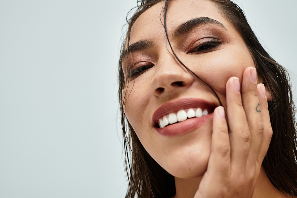 Smiling woman illustrating benefits of getting teeth veneers in Turkey