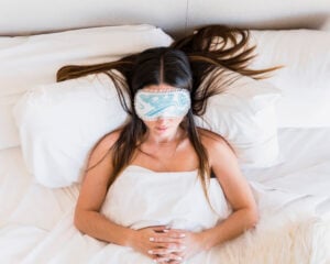 Woman sleeping on her back in a recovery position after tummy tuck surgery