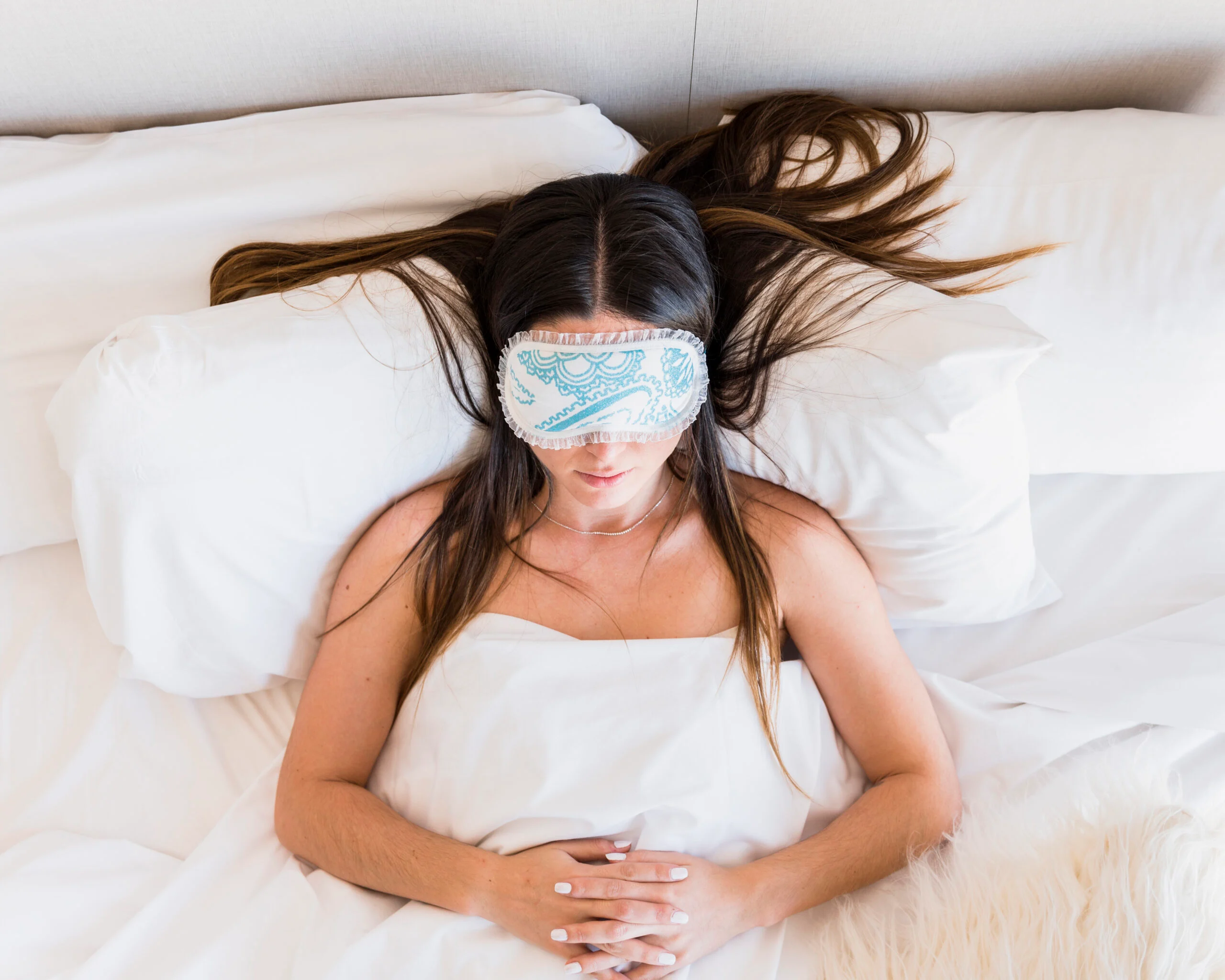 Woman sleeping on her back in a recovery position after tummy tuck surgery